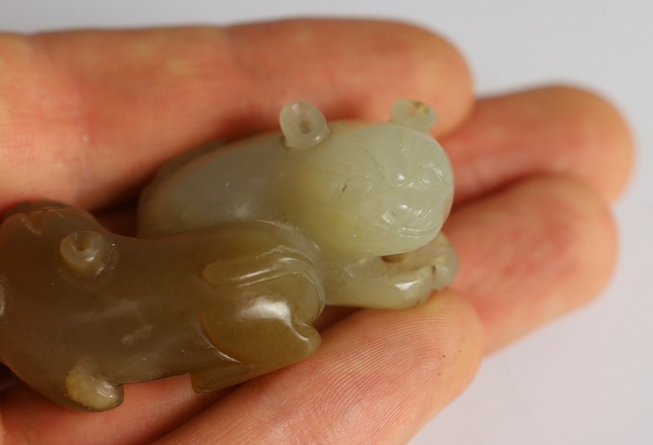 A Chinese pale celadon and brown jade group of two cats, 19th century, 5.1cm, wood stand, tiny chips